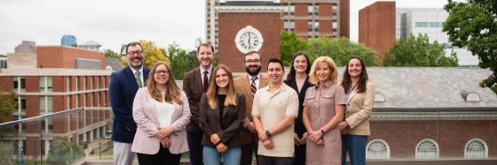 staff and students smiling with memorial hall in background